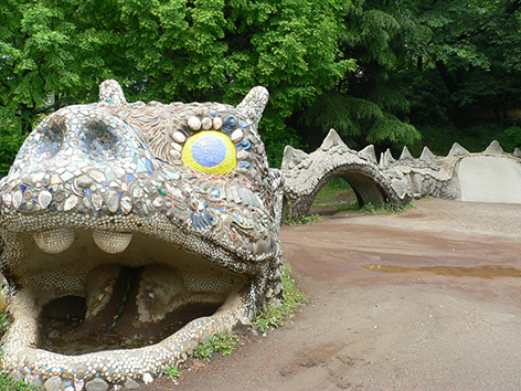 写真:砂場の大きなドラゴンの像。頭は色鮮やかなタイルなどで装飾され、胴体は子どもが上ったり潜ったりして遊べ、すべり台のようになっている部分もある