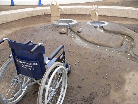 写真:小山の横からアプローチした車いすと、その座面奥から1メートルほど前方を流れている水路。ちなみに車いすに乗る大人の手の届く範囲の目安とされているのは60~65センチ