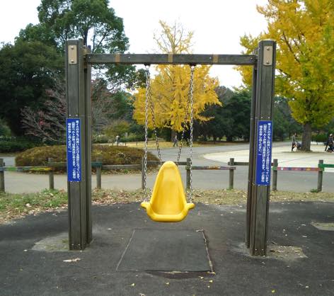 写真:高い背もたれのあるシート型のブランコ。両脇の支柱に看板。