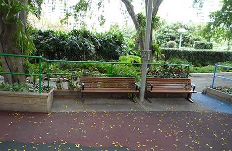 写真:2つのベンチが置かれたコーナー。ベンチと隣の花壇の間には1メートルほどの空間