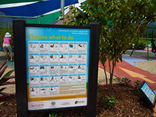 写真:遊び場の植栽部分に設置された大きな看板と小さな看板。