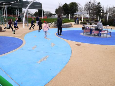 写真:遊具の間を縫うように延びる園路。遊び場に隣接するグアダループ川をイメージか。