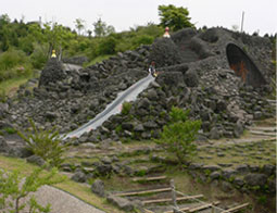 写真:溶岩谷の遊び場。黒い岩を積み上げた山の上につくられた滑り台