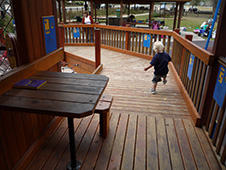 写真:幼い男の子がボタンを踏もうと懸命に足を上げているところ